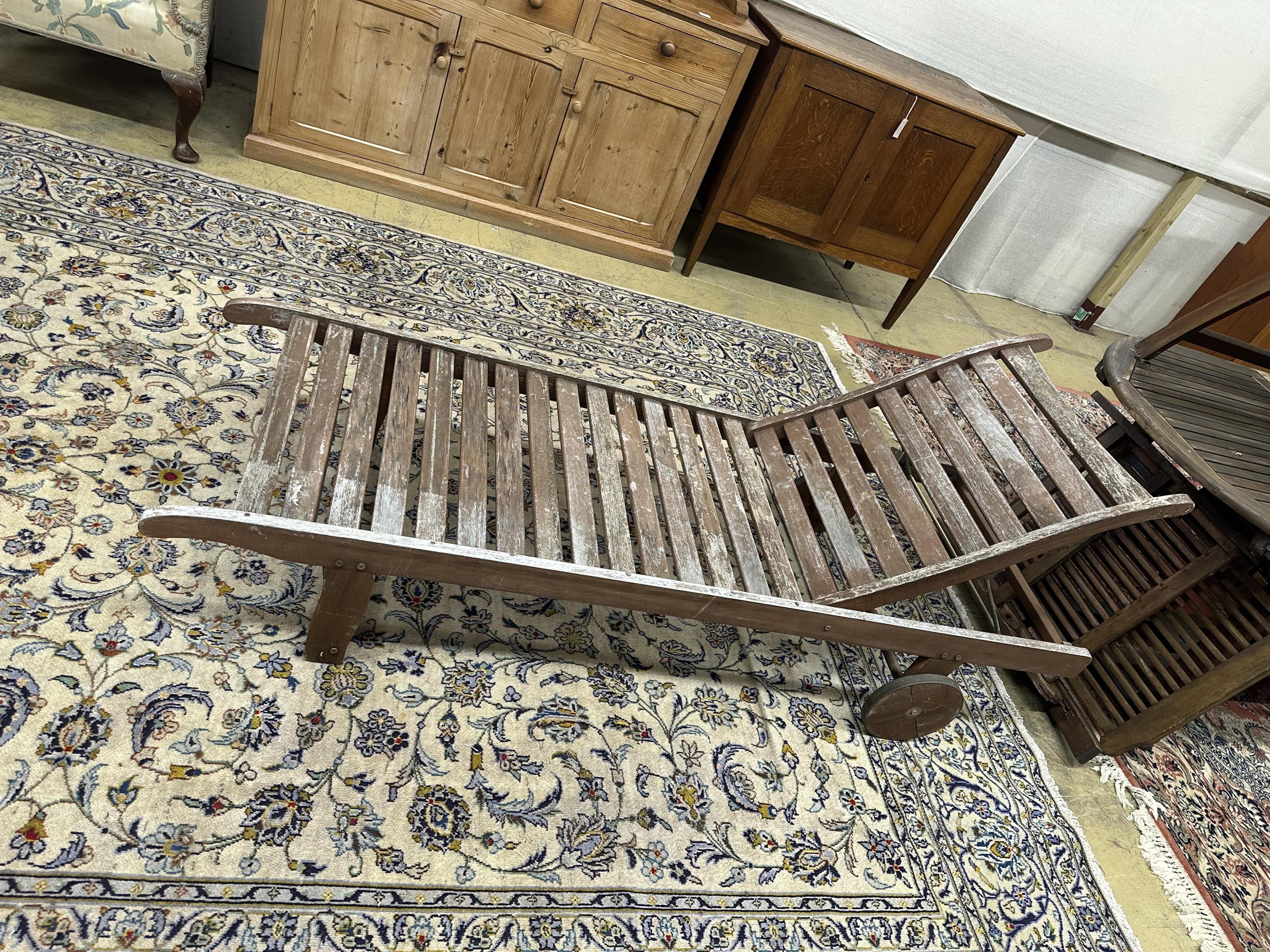 A pair of John Lewis weathered teak garden loungers and a folding occasional table. Condition - fair